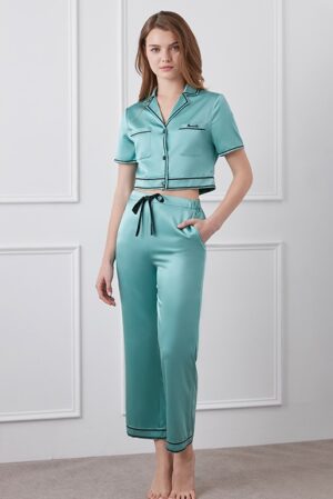 Elegant Greene Silk Pants with drawstring waist and trim detailing on a woman.