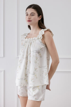 Woman displaying Princess Louise short pajama set with ruffle details.