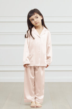 Young girl in a soft pink authentic silk pajama set looking happy.