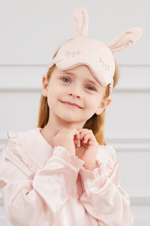 A child wears Bunny Child Eye Mask with rabbit ears and diamond eyelash detail, styled with silk pajamas.