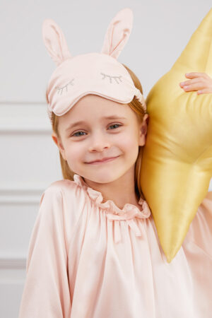 Smiling child poses in Bunny Child Eye Mask with soft silk fabric and rabbit ear shape.