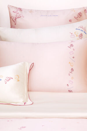 Close-up of Canelé Silk Bed Set featuring delicate embroidered details and a ruffled edge.