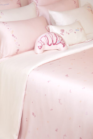 Canelé Pink Mulberry Silk Duvet Cover and Pillows displayed on a bed, exhibiting a soft and inviting sleep environment.