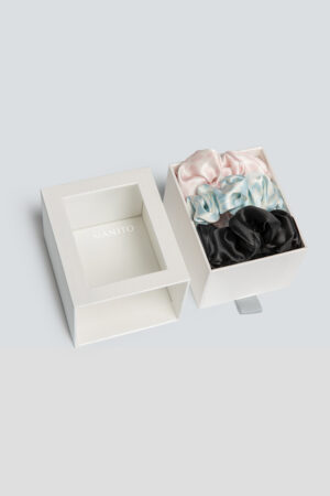 3 Pack Large Silk Scrunchie Set boxed in pink, blue, and black, a refined accessory designed to care for hair with grace.