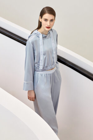 Woman wearing Sportif Silk Tracksuit with branded ribbon detailing, combining elegance with sporty style.