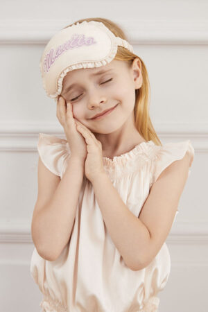 Model wears Fairy Kid's Eye Mask with MANITO embroidery, posing sweetly with closed eyes.