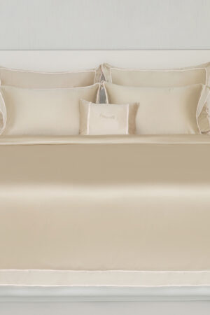 Side angle of a champagne MANITO Fringe Silk Duvet Cover on a bed, featuring luxurious bedroom ambiance.