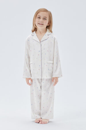 Full-body view of child in New Signature Kid's Pajama Set featuring two front pockets and lively design.
