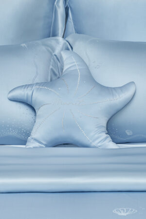 MANITO Ocean Starfish Throw Pillow on ocean blue bedding with embroidered marine motifs.