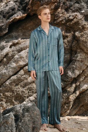 Front view of MANITO Ocean Stripe Men's Pajama Set with relaxed fit and vertical stripe design, styled against coastal rock background.