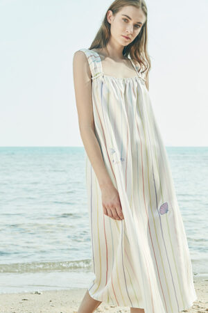 A front view of MANITO rainbow stripe dress, featuring thick straps and delicate embroidery of a dolphin and seashell.