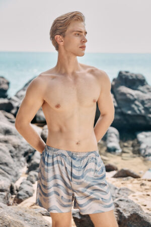 MANITO Ocean Wave Men's Shorts styled in a beach setting with a relaxed fit and wave pattern.