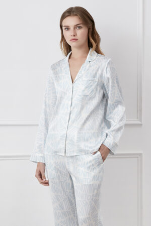 Woman in blue Script Silk Pajama Set for women with a subtle brand print, posing for a relaxed yet elegant look.