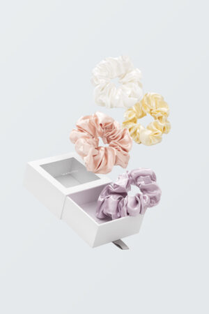 Thick Silk Scrunchies set—lilac, blush, ivory, butter yellow—floating above a windowed gift box.
