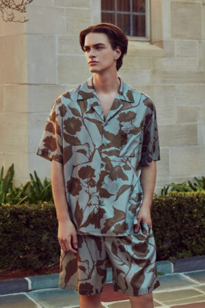 Model wears MANITO Tropical Men's Short Pajama Set in light taupe silk with vintage floral print.