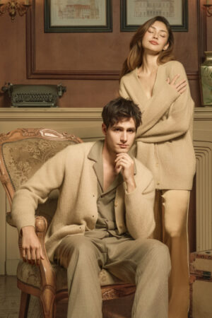 Man and woman in Wunder Cardigan, sitting and standing in a vintage room, evoking warmth and effortless elegance.