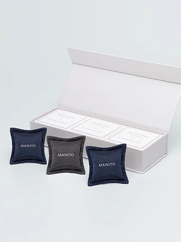 MANITO scented sachet gift set with navy and charcoal silk pouches, presented in an elegant white box.